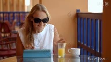 多利拍摄的年轻女子在咖啡馆露台上用笔记本电脑喝新<strong>鲜果汁</strong>，享受外面的风景
